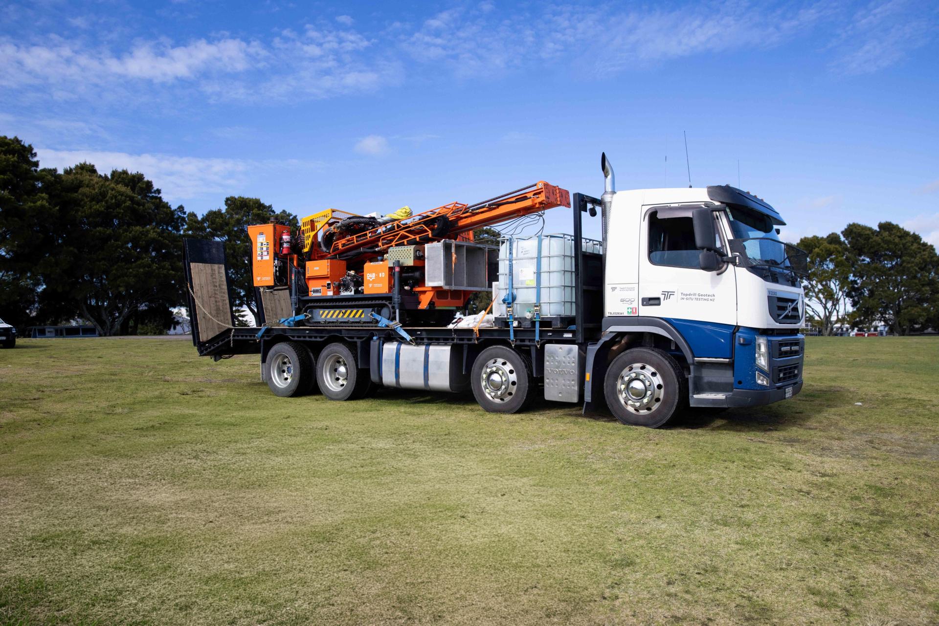 Side shot of borehole drilling machine loaded on truck