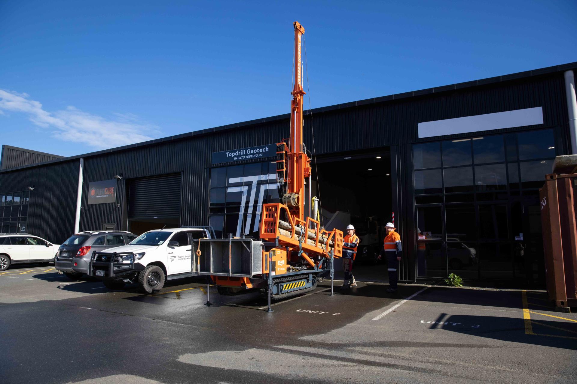 Borehole drilling machine and other vehicles parked outside Topdrill workshop