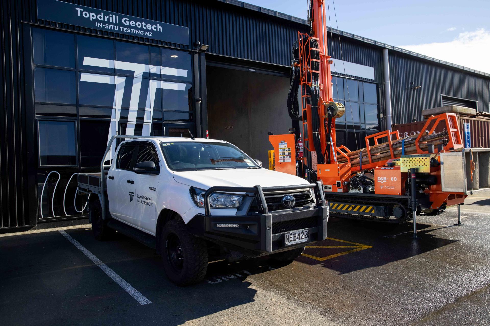 Borehole drilling machine and Topdrill ute parked outside Topdrill workshop